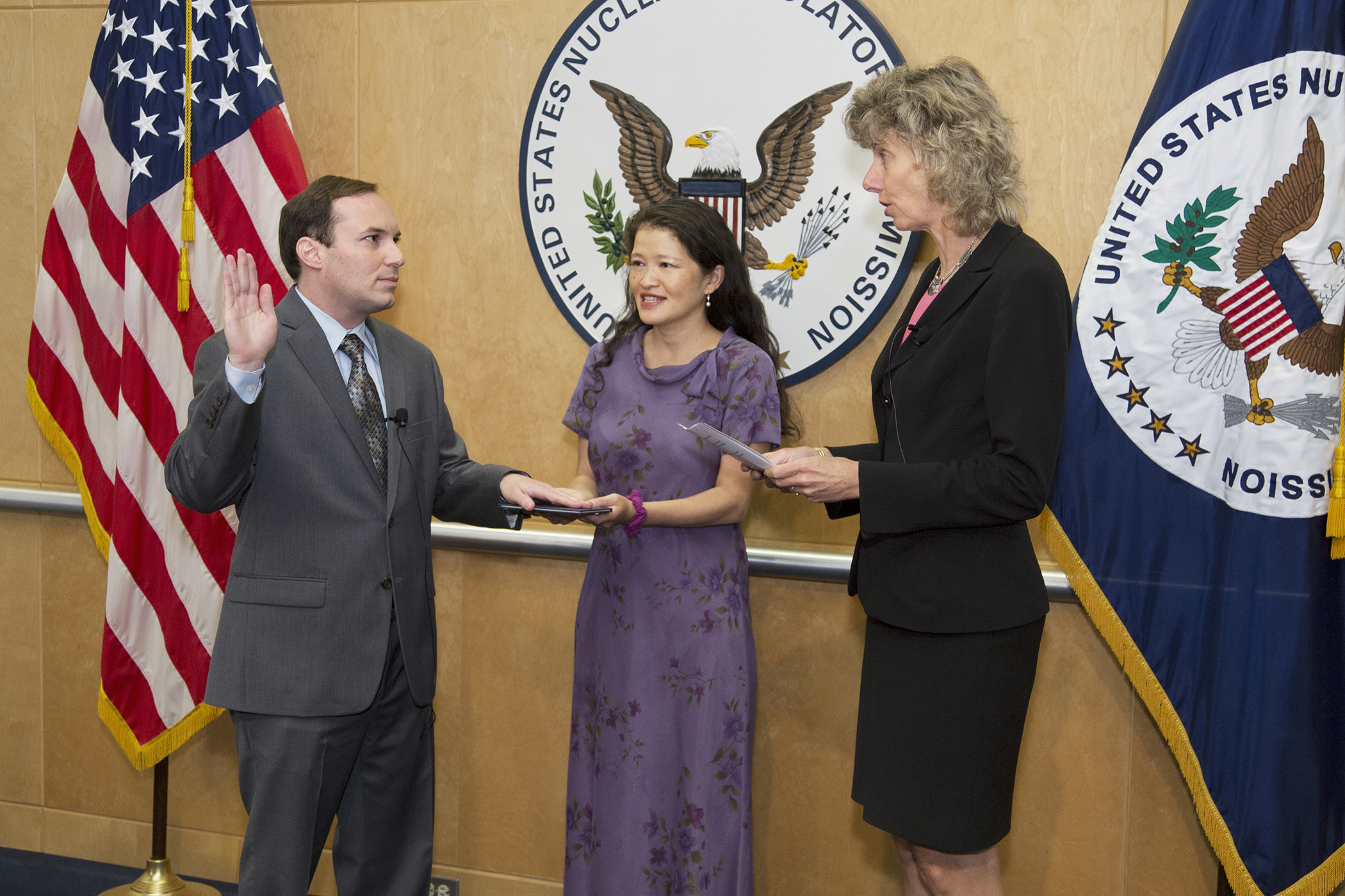 Jeff Baran is sworn in as a NRC commissioner by Chairman Allison M. Macfarlane (right) as his wife Michelle Yau looks on. (Source: NRC)