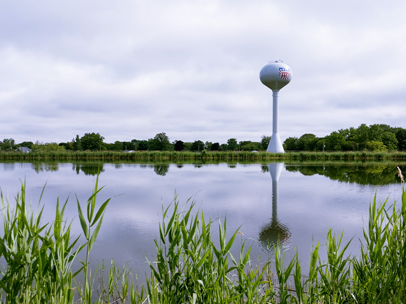 The water tower at the Cohoes, N.Y., reservoir broadcasts a message of civic pride. The city is planning to install a floating solar array on the water below.