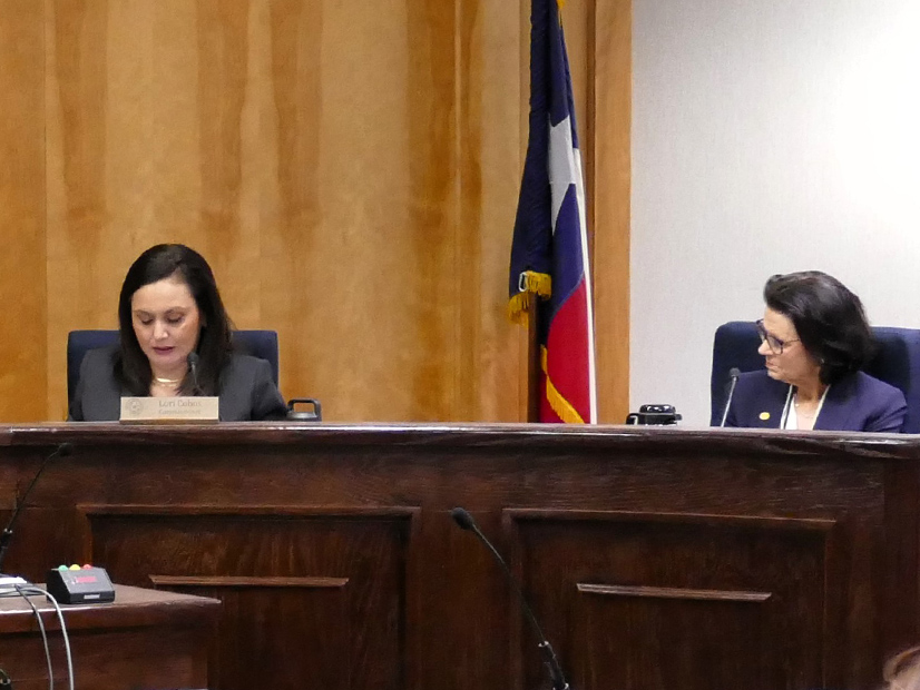 Kathleen Jackson (right) listens to Commissioner Lori Cobos during a recent Texas PUC open meeting.