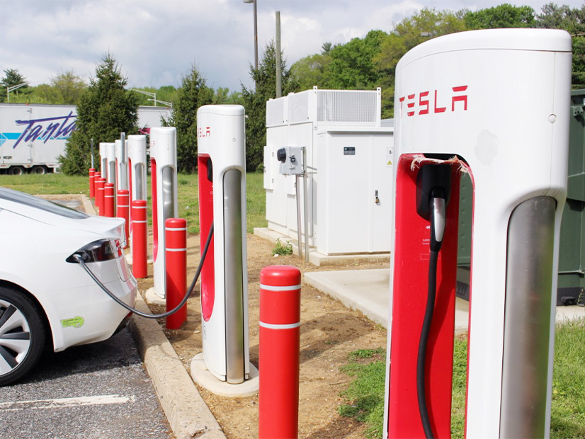 A Tesla electric vehicle charges at a row of existing chargers at the John Fenwick Service Area on the New Jersey Turnpike.