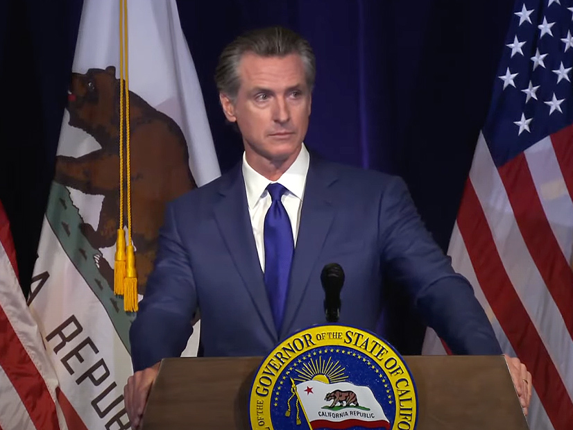 Gov. Gavin Newsom discusses his revised budget proposal in a press conference Friday.