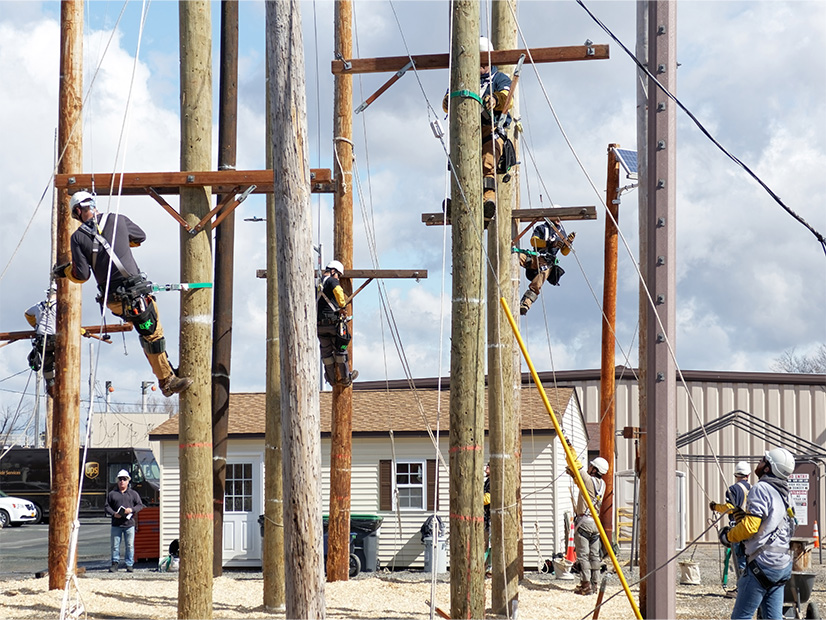 New apprentice line workers scale poles at National Grid's eastern New York training facility in Schenectady in March 2023.