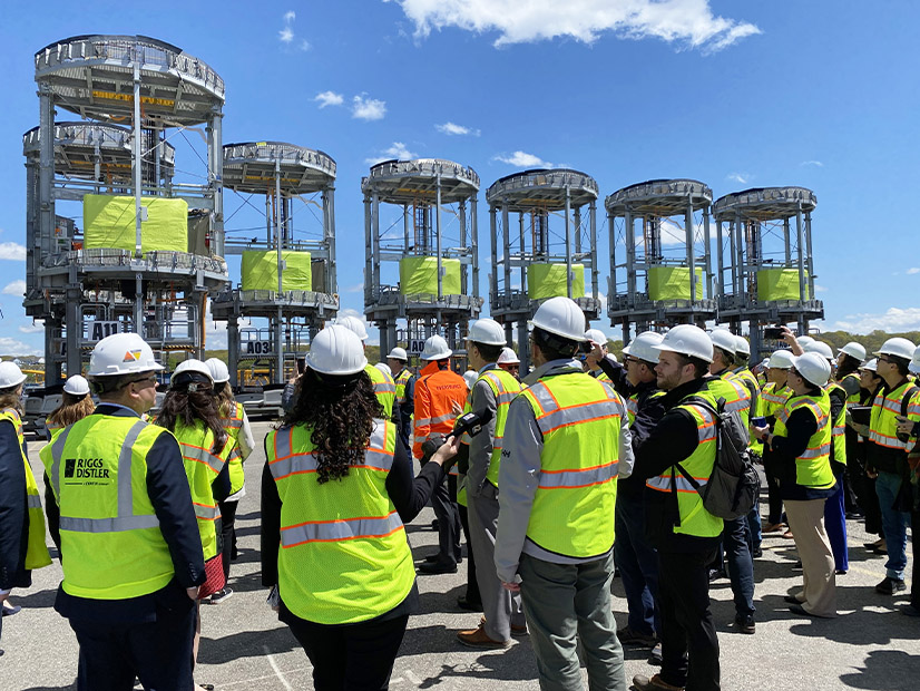 Officials and journalists tour a staging area in Providence, R.I., for offshore wind projects developed by Orsted and Eversource on May 1.