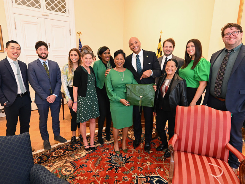 Maryland Gov. Wes Moore (fifth from right) and Secretary of Appointments Tisha Edwards (to Moore's left) prepare to send the state's Green Bag, containing more than 300 gubernatorial appointments, to the General Assembly.