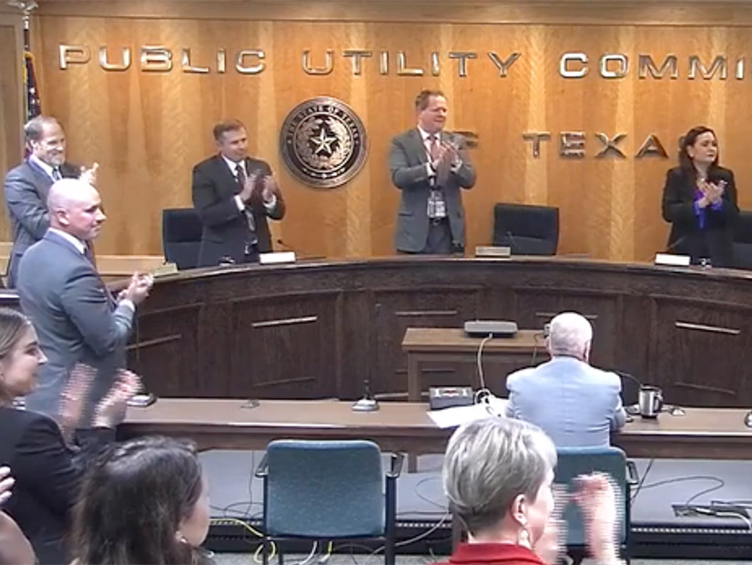 The Texas PUC's commissioners honor retiring interim CEO Brad Jones with a standing ovation.