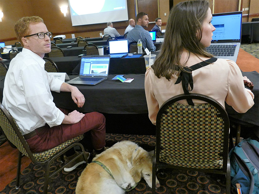 Morgan, a golden retriever catching some Zs between Puget Sound Energy's Greg Macdonald and Catherine Whitten, her owner, was among the attendees for both Markets+ sessions.