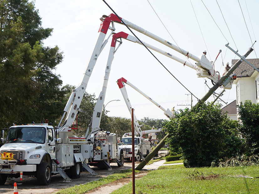 Utility workers restore downed power lines in Louisiana following last year's Hurricane Ida.