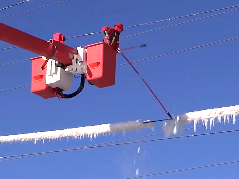 Lineman clear ice from transmission lines