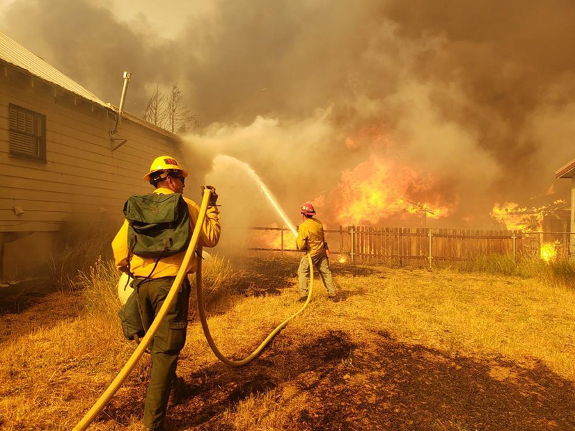 Firefighters try to protect a home in Greenville, Calif., a community destroyed by the Dixie Fire in August. 