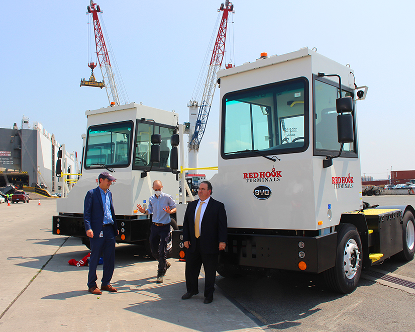 Mike Stamatis (right), CEO of Red Hook Container Terminals, in front of two of the ten electric yard tractors showcased Wednesday in Port Newark, NJ.