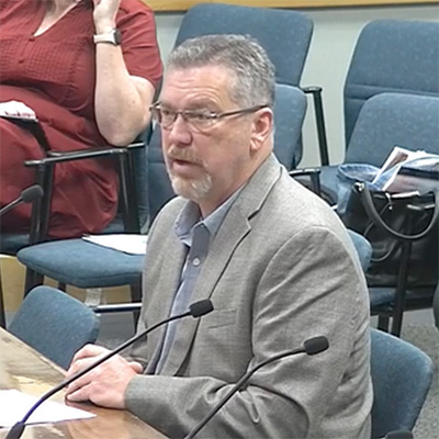 PUC Chair Peter Lake (center) discusses the commission's upcoming schedule with Will McAdams, Lori Cobos