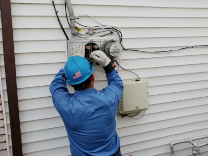 A Con Edison worker connects an adapter that uses the residential electric meter socket as a point of interconnection for solar power.
