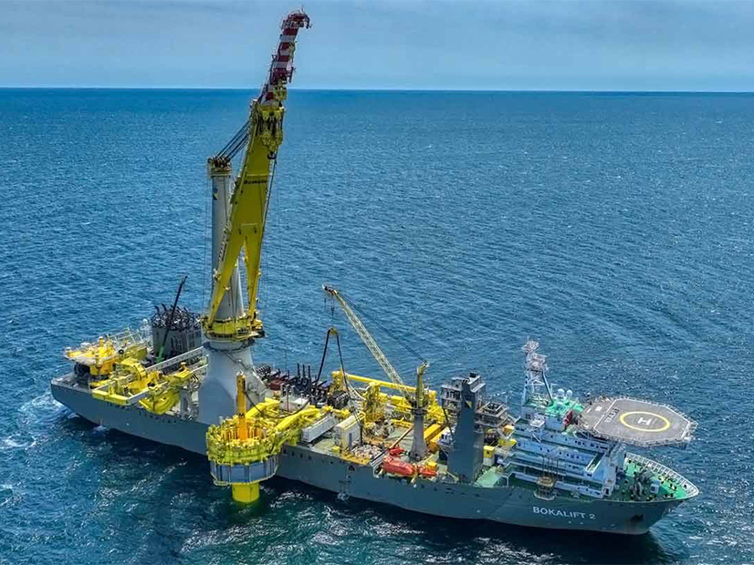 Workers on the heavy lift vessel Bokalift 2 install the first monopile foundation for the South Fork Wind project off the cost of New York.