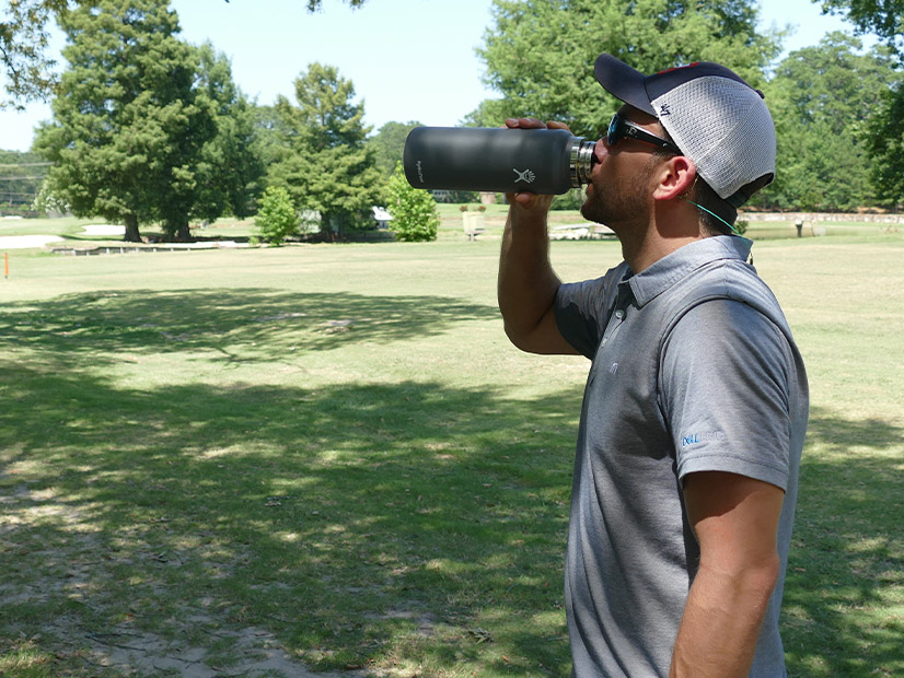 Resident golfer Eric Newberry takes a water break during 99 degree temperatures Tuesday before finishing 18 holes in Conroe, Texas.