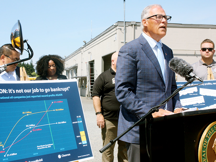 Gov. Jay Inslee defended Washington's cap-and-trade program during a press conference at a school bus depot in Burien.