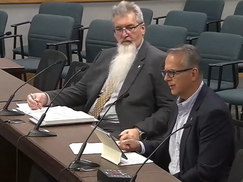 ERCOT CFO Sean Taylor (left) listens to CEO Pablo Vegas' budget discussion.