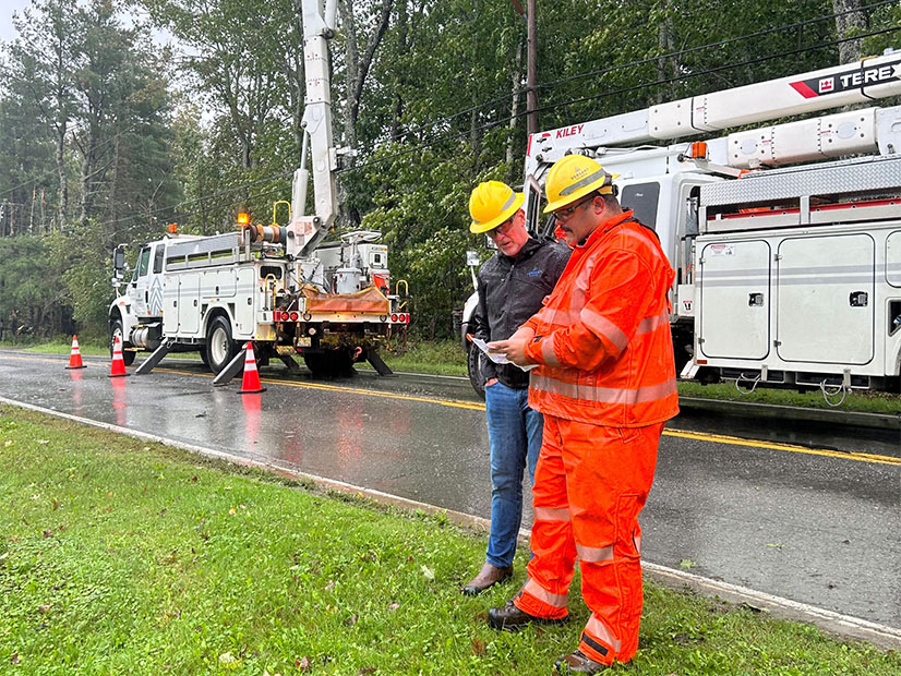 Versant Power President John Flynn checks in with a line worker doing a storm related outage Sept. 16 in Brewer, Maine.