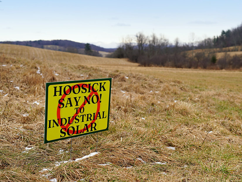 Anti-solar power sentiment is displayed in a farm field near Hoosick Falls, N.Y., in January 2024.