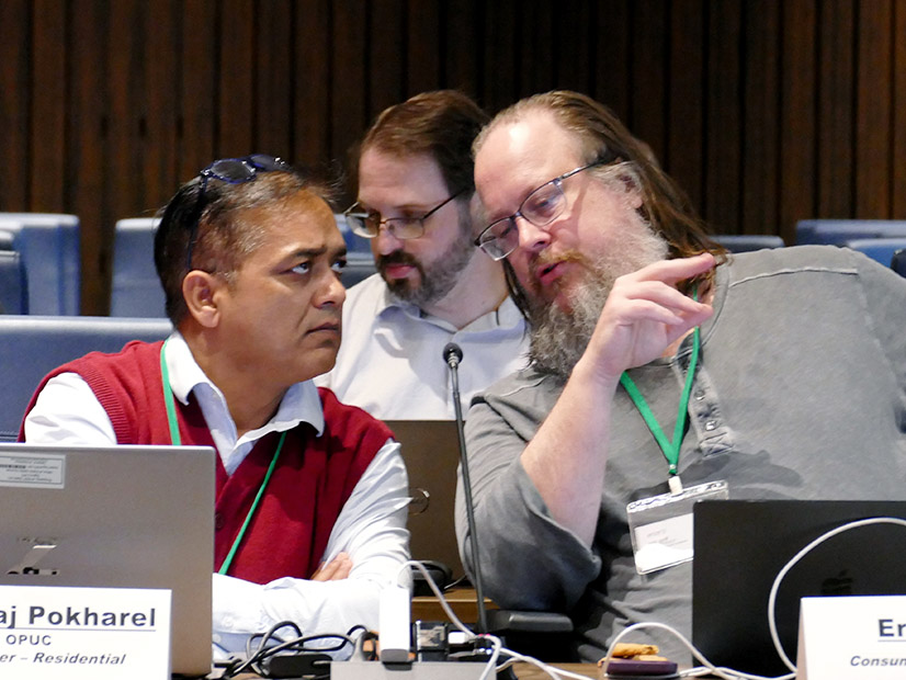 Consumer representative Eric Goff discusses an ERCOT proposal with OPUC's Nabaraj Pokharel. 