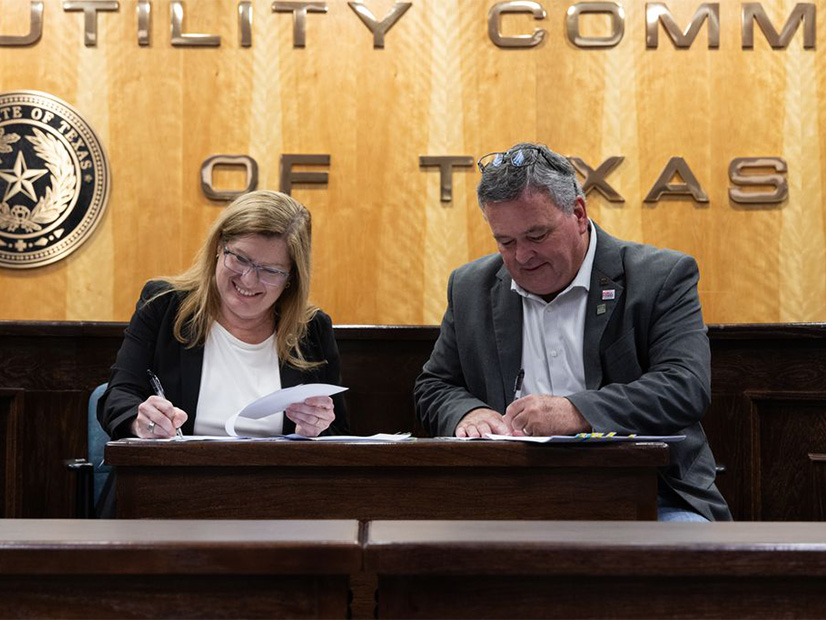 PUC Executive Director Connie Corona (left) and Kerrville CEO Mike Wittler sign the first Texas Energy Fund loan agreement. 
