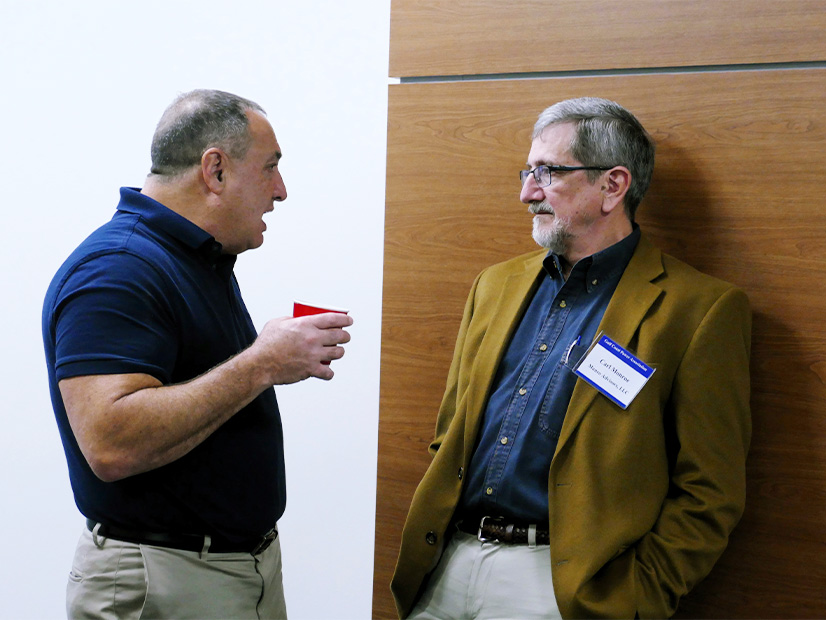 Carl Monroe (right) listens to attorney Bill Booth, a partner at Michael Best & Friedrich, during an industry conference.